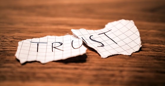 Torn paper with word trust on it